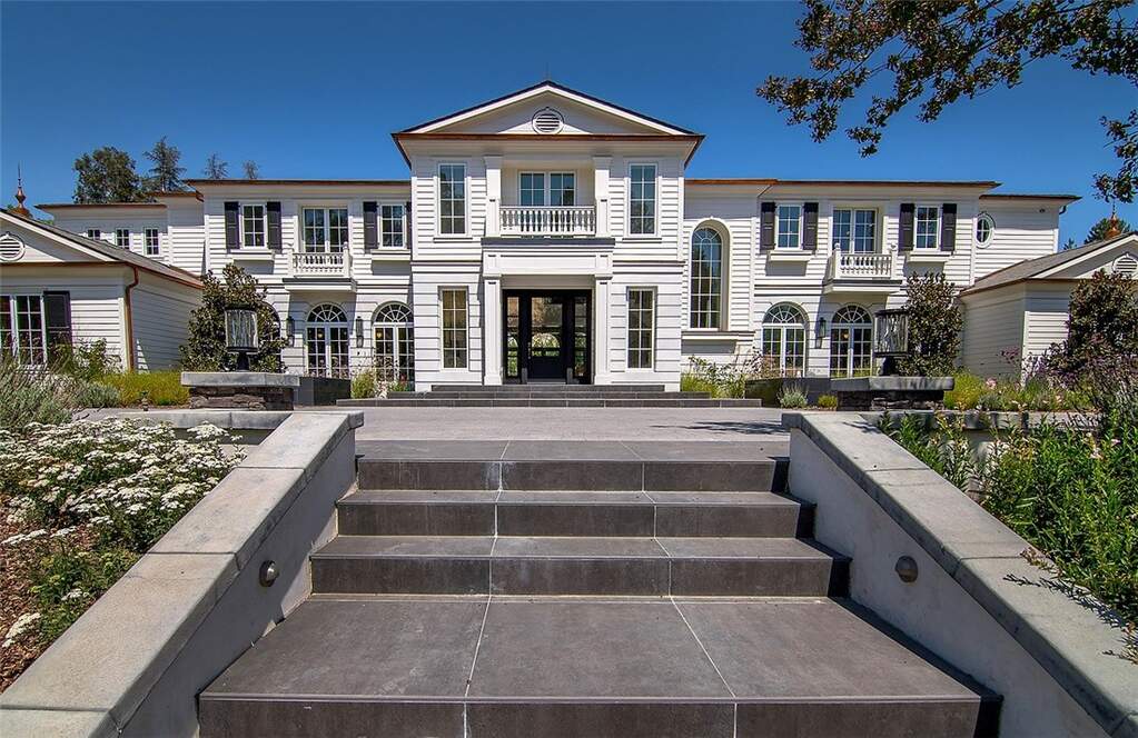 Estate entrance with circular driveway and stone fountains